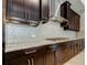 Modern kitchen with dark cabinets, stainless steel range hood, and sleek countertops at 4975 Night Star Trl, Odessa, FL 33556