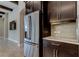 Modern kitchen featuring stainless steel refrigerator and dark wood cabinets with light countertops and backsplash at 4975 Night Star Trl, Odessa, FL 33556