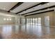 Open-concept living room with exposed beams, tile flooring, and large windows with views of the pool at 4975 Night Star Trl, Odessa, FL 33556