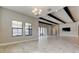 Bright living room with dark ceiling beams leading into dining and kitchen area at 4975 Night Star Trl, Odessa, FL 33556