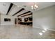 Open concept living room with dark kitchen island and wooden beams at 4975 Night Star Trl, Odessa, FL 33556