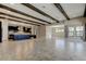 Open living room with dark kitchen island and wood beam ceiling at 4975 Night Star Trl, Odessa, FL 33556