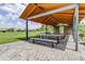 Shaded outdoor picnic area with stone flooring, wooden tables, benches, and green lawn at 4975 Night Star Trl, Odessa, FL 33556