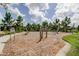 Outdoor playground featuring an area covered in wood chips, wooden climbing structures and lush greenery at 4975 Night Star Trl, Odessa, FL 33556
