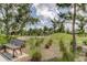 Community playground featuring natural play structures, wooden bench, and lush landscaping at 4975 Night Star Trl, Odessa, FL 33556