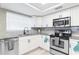 Well-lit kitchen featuring stainless steel appliances, granite countertops, and sleek, white cabinetry at 512 Flamingo Dr, Apollo Beach, FL 33572