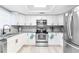Modern kitchen features sleek white cabinets, stainless steel appliances, and granite countertops at 512 Flamingo Dr, Apollo Beach, FL 33572