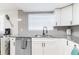 Modern kitchen features white cabinets, stainless steel appliances, and ample counter space at 512 Flamingo Dr, Apollo Beach, FL 33572