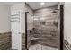 Bathroom features walk in shower with corner seats, custom brown tile, frameless glass door, and modern fixtures at 6607 Gates Pointe Way, Riverview, FL 33578