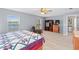 Spacious bedroom with two windows, ceiling fan, wood floors, comfortable chair, and adjacent mini fridge at 6607 Gates Pointe Way, Riverview, FL 33578