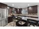 Open kitchen featuring stainless steel appliances, a central island, and dark wood cabinets at 6607 Gates Pointe Way, Riverview, FL 33578