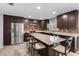 Kitchen featuring a large island with seating, stainless steel appliances, and tiled backsplash at 6607 Gates Pointe Way, Riverview, FL 33578