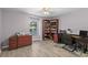 Home office with a wooden desk, bookcase, and laminate floors at 6607 Gates Pointe Way, Riverview, FL 33578