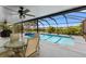 Screened-in pool area with ample seating, a ceiling fan, and a view of the lake at 6607 Gates Pointe Way, Riverview, FL 33578