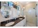 Bathroom boasts dual sinks with granite counters, framed mirrors and a glass-enclosed shower at 708 Sandy Hills Ave, Tarpon Springs, FL 34689