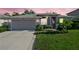 Well-maintained single-story home featuring a lush lawn, mature landscaping, gray roof, and a two-car garage for comfortable living at 708 Sandy Hills Ave, Tarpon Springs, FL 34689