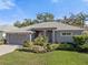 Charming single-story home featuring a well-manicured lawn and lush landscaping at 708 Sandy Hills Ave, Tarpon Springs, FL 34689
