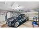 Spacious garage featuring a black SUV, storage cabinets, and an automatic garage door opener and room for parking at 708 Sandy Hills Ave, Tarpon Springs, FL 34689