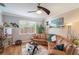 Relaxing living room with wood floors, ceiling fan, large window, and a comfortable L-shaped sofa at 708 Sandy Hills Ave, Tarpon Springs, FL 34689