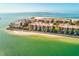 An aerial photograph showcasing the oceanfront condos with private beach access and clear turquoise water at 7480 Bayshore Dr # 402, Treasure Island, FL 33706