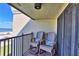 Balcony featuring two wooden Adirondack chairs with tropical patterned pillows and ocean views at 7480 Bayshore Dr # 402, Treasure Island, FL 33706