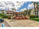 Exterior view of a charming clubhouse with red brick stairs, lush landscaping, and an American flag at 7480 Bayshore Dr # 402, Treasure Island, FL 33706