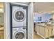 Convenient in-unit laundry featuring a stacked washer and dryer, adjacent to the kitchen and sink at 7480 Bayshore Dr # 402, Treasure Island, FL 33706