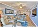 Comfortable living room with blue accents, tile flooring, and view into open concept kitchen at 7480 Bayshore Dr # 402, Treasure Island, FL 33706
