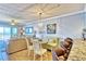 Bright, open-concept living space with tile floors, coastal decor, and balcony access at 7480 Bayshore Dr # 402, Treasure Island, FL 33706