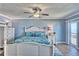 Serene bedroom with beach-themed decor, ceiling fan, and balcony access with ocean views at 7480 Bayshore Dr # 402, Treasure Island, FL 33706