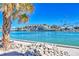 Beautiful waterfront view of the building, a palm tree and the waterway on a sunny day at 7480 Bayshore Dr # 402, Treasure Island, FL 33706