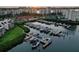 Aerial view of community marina with boats docked, manicured lawns, condos, and view of the sunset at 7872 Sailboat Key S Blvd # 306, South Pasadena, FL 33707
