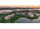 Aerial view of condo community surrounded by water, mature landscaping, and views of the city and sunset at 7872 Sailboat Key S Blvd # 306, South Pasadena, FL 33707