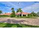 Exterior shot of community clubhouse surrounded by manicured lawns and palm trees with circular brick entrance at 7872 Sailboat Key S Blvd # 306, South Pasadena, FL 33707