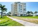 Exterior of a multi-story condo building with manicured lawns and palm trees, offering a glimpse of luxurious living at 7872 Sailboat Key S Blvd # 306, South Pasadena, FL 33707