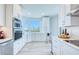 Modern kitchen boasting white cabinets, quartz countertops, stainless steel appliances, and a scenic view from its bay window at 7872 Sailboat Key S Blvd # 306, South Pasadena, FL 33707
