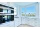 Modern kitchen with stainless steel appliances, white cabinetry, and a stunning view from a large bay window at 7872 Sailboat Key S Blvd # 306, South Pasadena, FL 33707