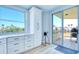 Bright kitchen featuring white cabinets, a modern backsplash, stainless steel appliances, and balcony access at 7872 Sailboat Key S Blvd # 306, South Pasadena, FL 33707