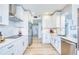 Open kitchen layout with modern stainless steel appliances, white cabinets, and a sleek tile backsplash at 7872 Sailboat Key S Blvd # 306, South Pasadena, FL 33707