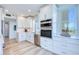 Modern kitchen with stainless steel appliances, white cabinets, tiled backsplash and scenic water view at 7872 Sailboat Key S Blvd # 306, South Pasadena, FL 33707