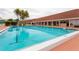 Large outdoor pool with lounge chairs, tables and palm trees, with a covered area for relaxation at 7872 Sailboat Key S Blvd # 306, South Pasadena, FL 33707