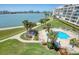 Aerial view of a community pool and buildings with clear water and lounge chairs at 7872 Sailboat Key S Blvd # 306, South Pasadena, FL 33707