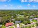 A sprawling aerial view captures a neighborhood, showcasing roof lines and verdant tree canopies under a brilliant sky at 8231 31St N Ter, St Petersburg, FL 33710