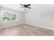 Bright bedroom with light wood floors, ceiling fan, and a large window for plenty of natural light at 8231 31St N Ter, St Petersburg, FL 33710