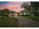 Charming single-story home featuring a lush front yard, paver driveway, and beautiful landscaping at sunset at 8231 31St N Ter, St Petersburg, FL 33710