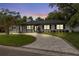 Charming single-story home boasts a modern exterior with a curved driveway, lush lawn, and ample curb appeal at 8231 31St N Ter, St Petersburg, FL 33710