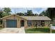 Charming single-story home with a stone accent wall, well-maintained lawn, and attached garage at 8317 Needles Dr, Hudson, FL 34667