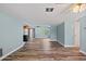 Open-concept living area with wood-look floors and easy access to kitchen and hallway at 8317 Needles Dr, Hudson, FL 34667