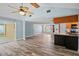 Open-concept living area with wood-look floors and easy access to kitchen and hallway at 8317 Needles Dr, Hudson, FL 34667