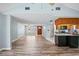 Open-concept living area with wood-look floors and easy access to kitchen and front entry at 8317 Needles Dr, Hudson, FL 34667